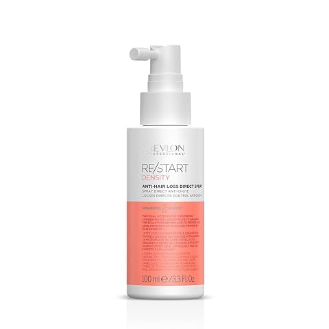 Flacon vaporisateur de soin capillaire Re/Start Density posé sur une pierre claire dans une salle de bain