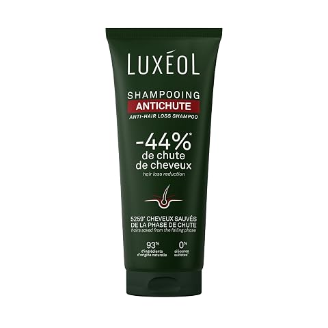 Flacon compact de shampoing Luxéol posé sur une pierre claire dans une salle de bain épurée.