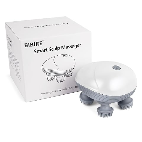 Masseur électrique de cuir chevelu blanc et gris à quatre têtes en silicone, posé sur une pierre claire.