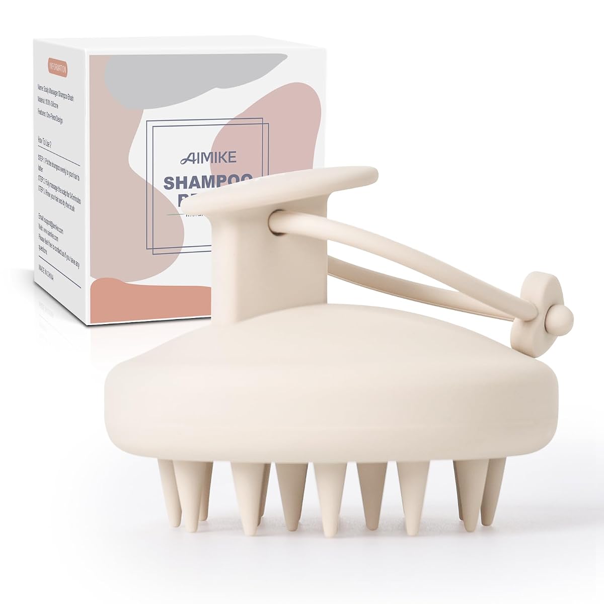 Brosse compacte en silicone avoine avec picots de massage et cordon, posée sur une pierre claire