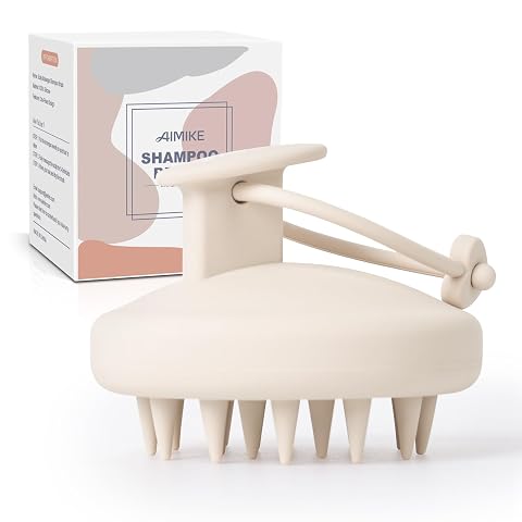 Brosse compacte en silicone avoine avec picots de massage et cordon, posée sur une pierre claire