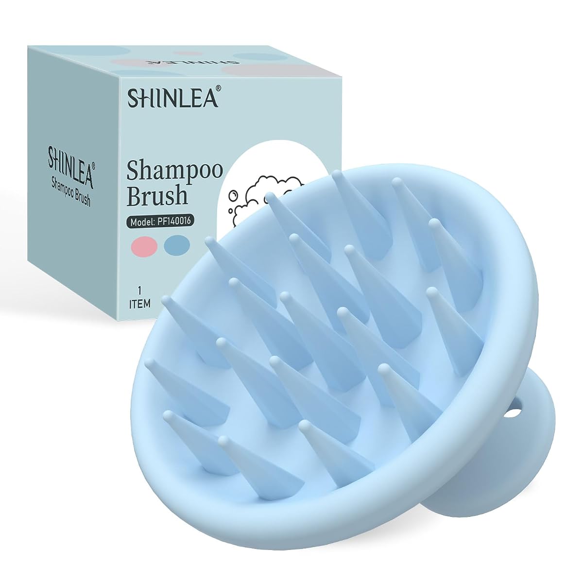 Brosse de massage du cuir chevelu en silicone bleu posée sur une pierre claire dans une salle de bain.