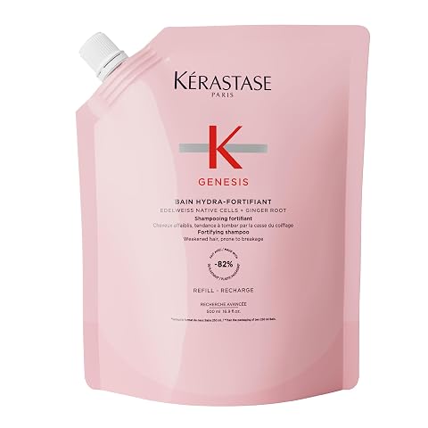 Recharge de shampoing Kérastase Genesis posée sur une pierre claire dans une salle de bain épurée.