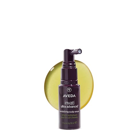 Flacon ivoire de sérum revitalisant pour le cuir chevelu posé sur une pierre claire.