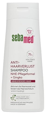 Flacon blanc de shampooing Sebamed posé sur une tablette en pierre claire dans une salle de bain épurée.