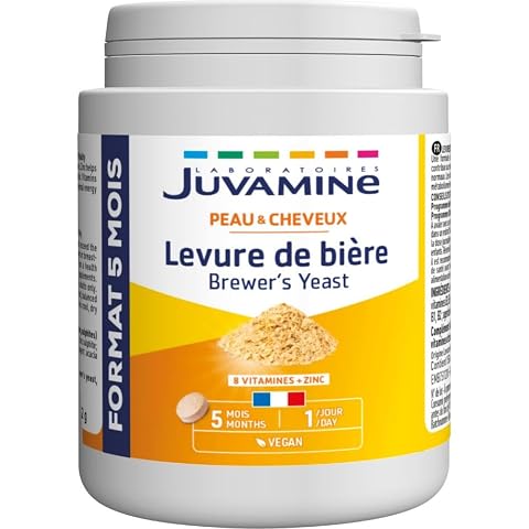 Flacon de complément à la levure de bière avec quelques comprimés sur une pierre claire