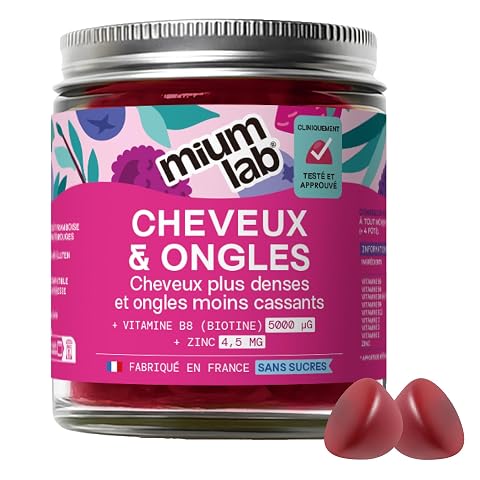 Gummies fruitées pour cheveux près d’un pot neutre, sur une surface en pierre claire
