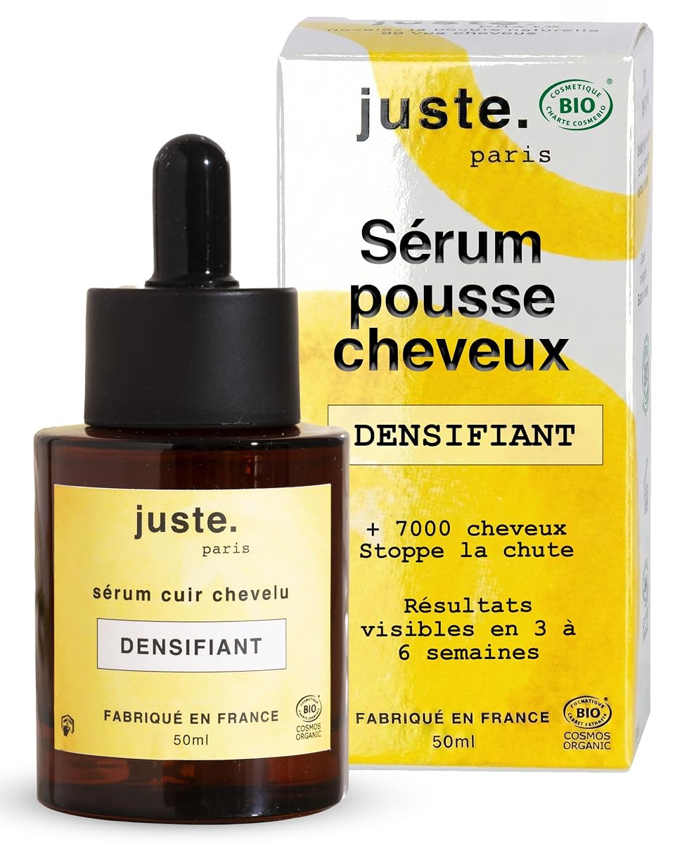 Flacon jaune de sérum capillaire posé sur une pierre claire dans une salle de bain épurée.